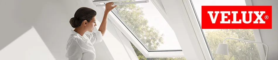 Vrouw bedient Velux dakraam met handbediening in een ruimte met natuurlijk licht