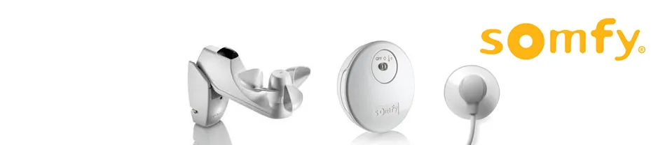 Drie Somfy sensoren: regen- en windsensor, ronde draadloze sensor en ronde bedieningsknop met logo