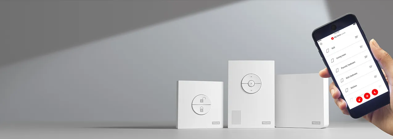 Drie Velux bedieningspanelen met verschillende functies en een smartphone met app voor afstandsbediening