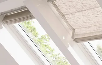 Rood Velux-logo op een houten achtergrond bij een raam